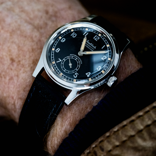 Close-up of a Aeschbach 1944 x Enoksen worn on wrist. Looking cool and stylish with the polished steel case and black dial.