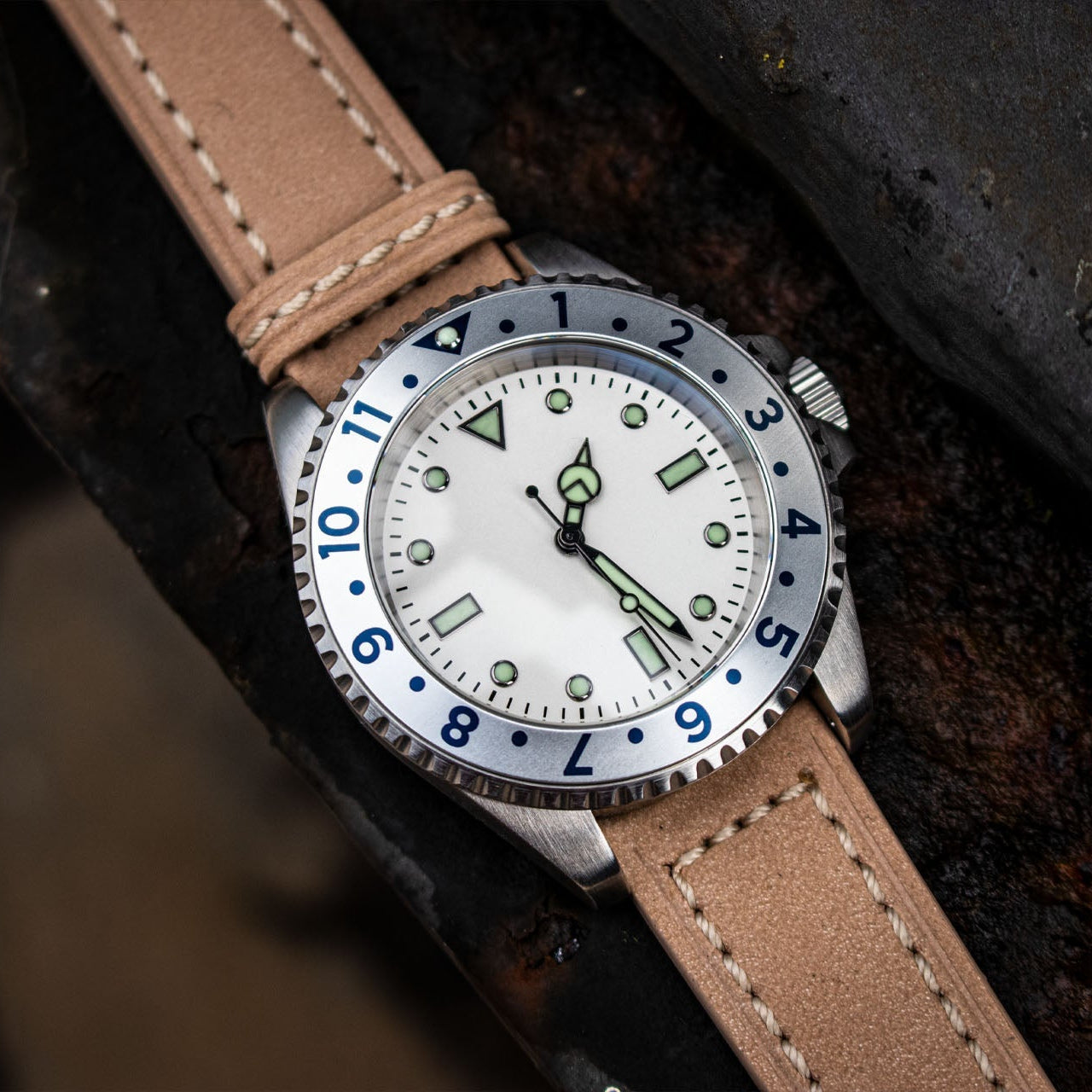Watch with a brown leather strap on a dark textured background