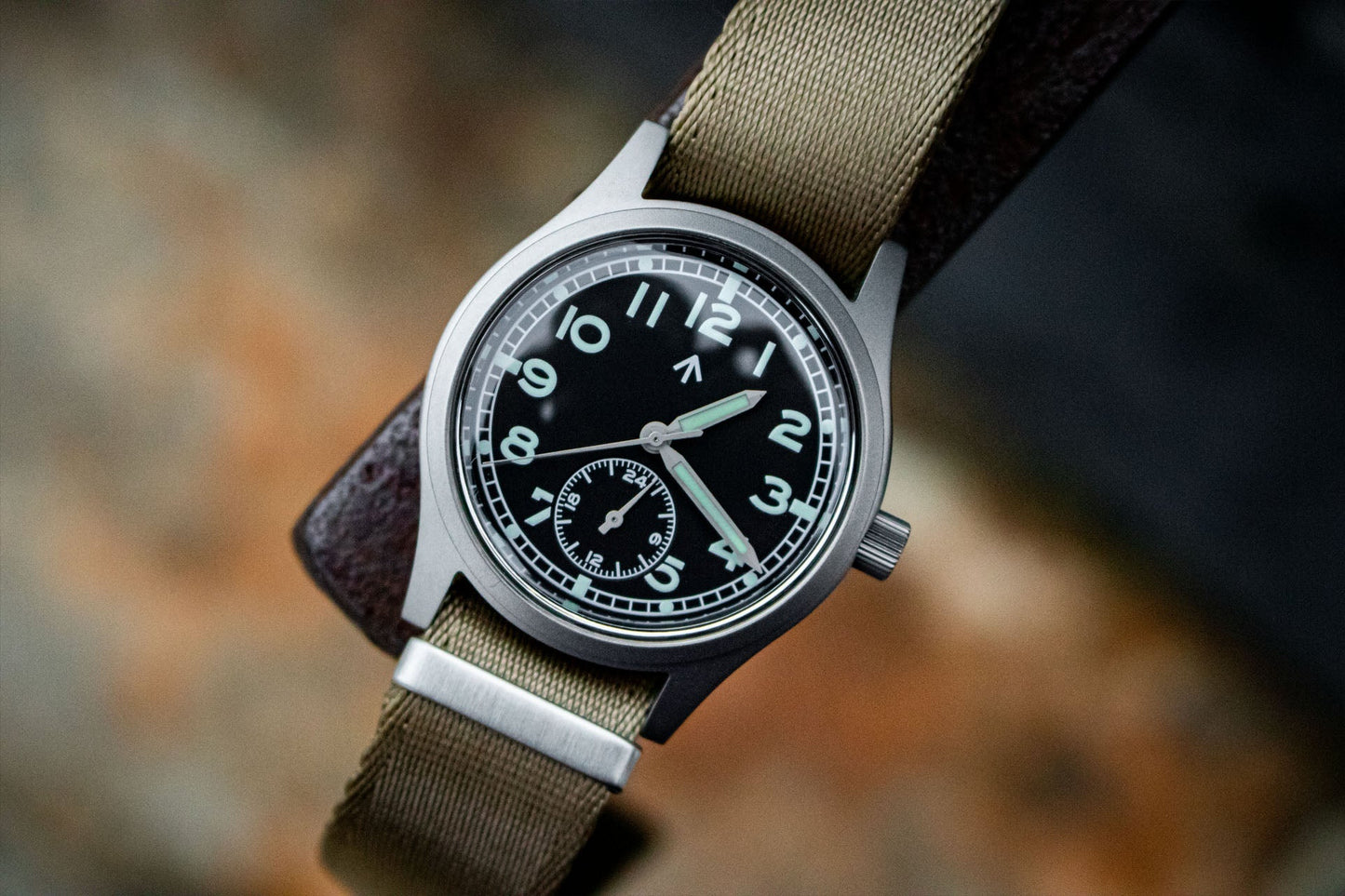 Close-up of the black dial of the Aeschbach x Enoksen 'Fly' E03/H watch, highlighting the white markers, Super-Luminova, and 24-hour hand.