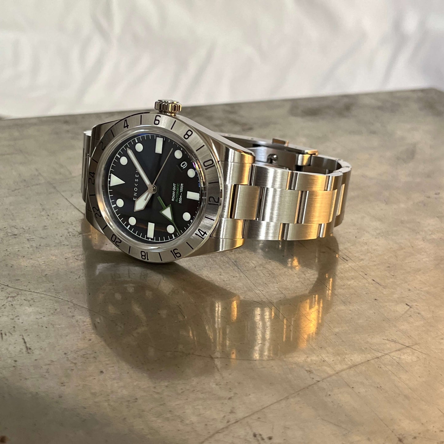 A side-on view showcasing the polished steel case of By Enoksen Tactical watch. The image emphasizes the watch's study build crown and rotating bezel.