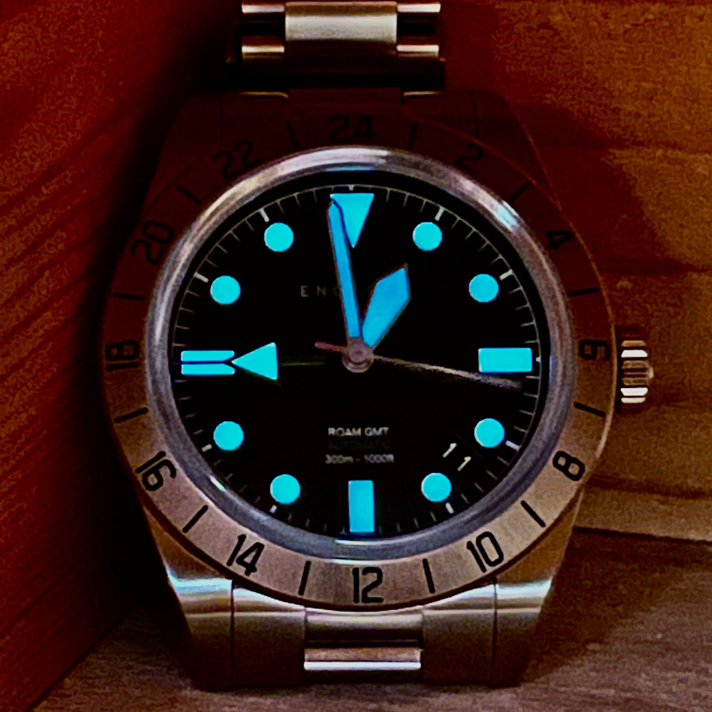 Front view of the watch in darkness showcasing the bright blue luminescent on the hands and minute markers, adding great visibility to the watch.