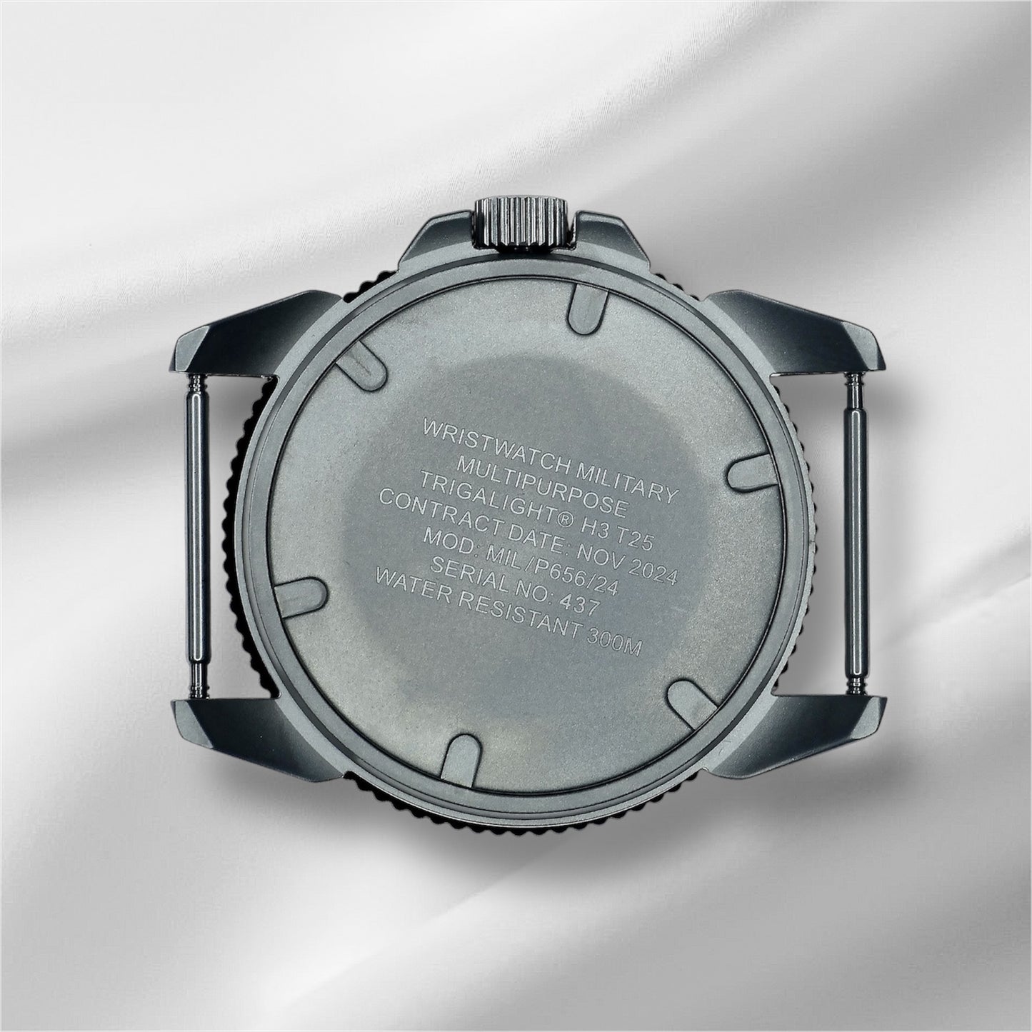 Close up of the backside of the watch case. Showing the specifications and serial number of the watch engraved on the case.