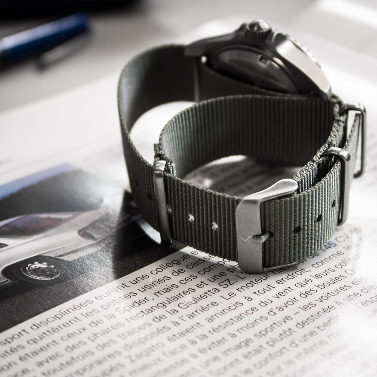 Watch with a black strap on a magazine page