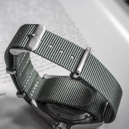 Silver watch with a textured strap on a blurred background