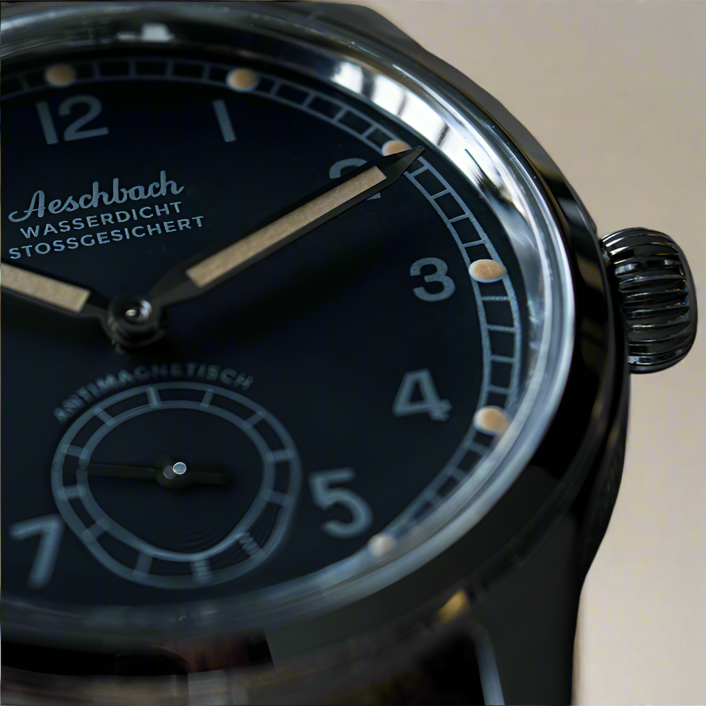 Close up af Aeschbach 1944 showcasing the black vintage style dial with the text: Wasserdicht stossgesichert