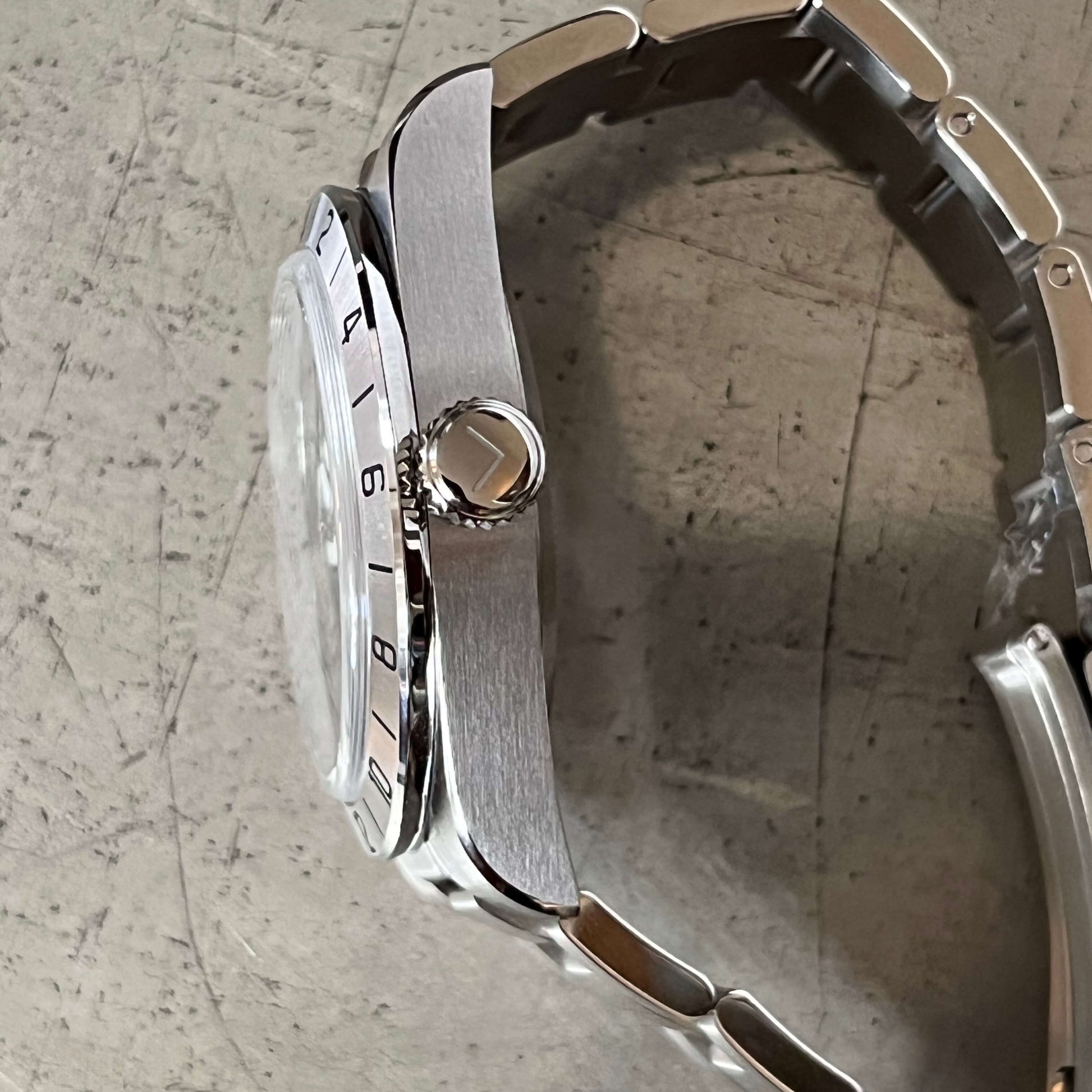 Side close-up view of the Roam E07/B, highlighting the Enoksen logo crown and silver link bracelet, showcasing the craftsmanship of By Enoksen.