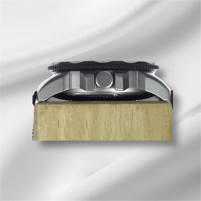 A side-on view showcasing the polished steel case of By Enoksen Tactical watch. The image emphasizes the watch's study build crown and black rotating bezel.