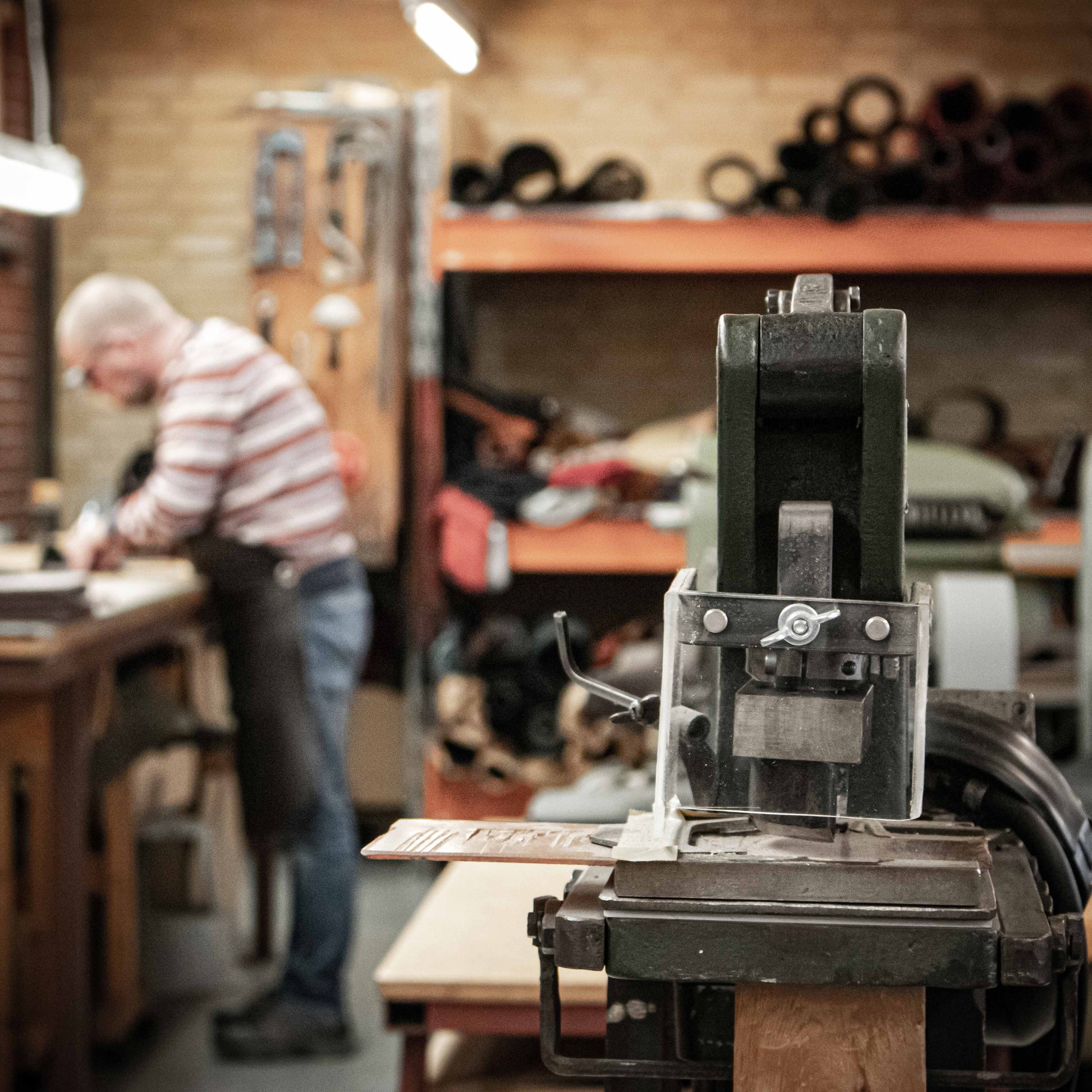 Person working in a workshop with machinery and tools.