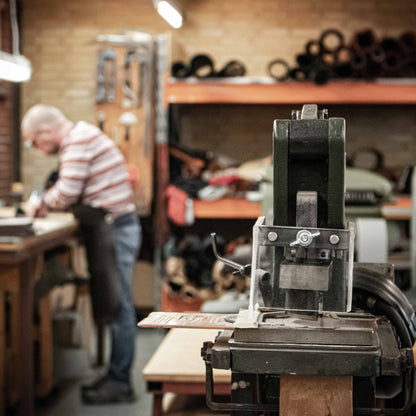 Person working in a workshop with machinery and tools.
