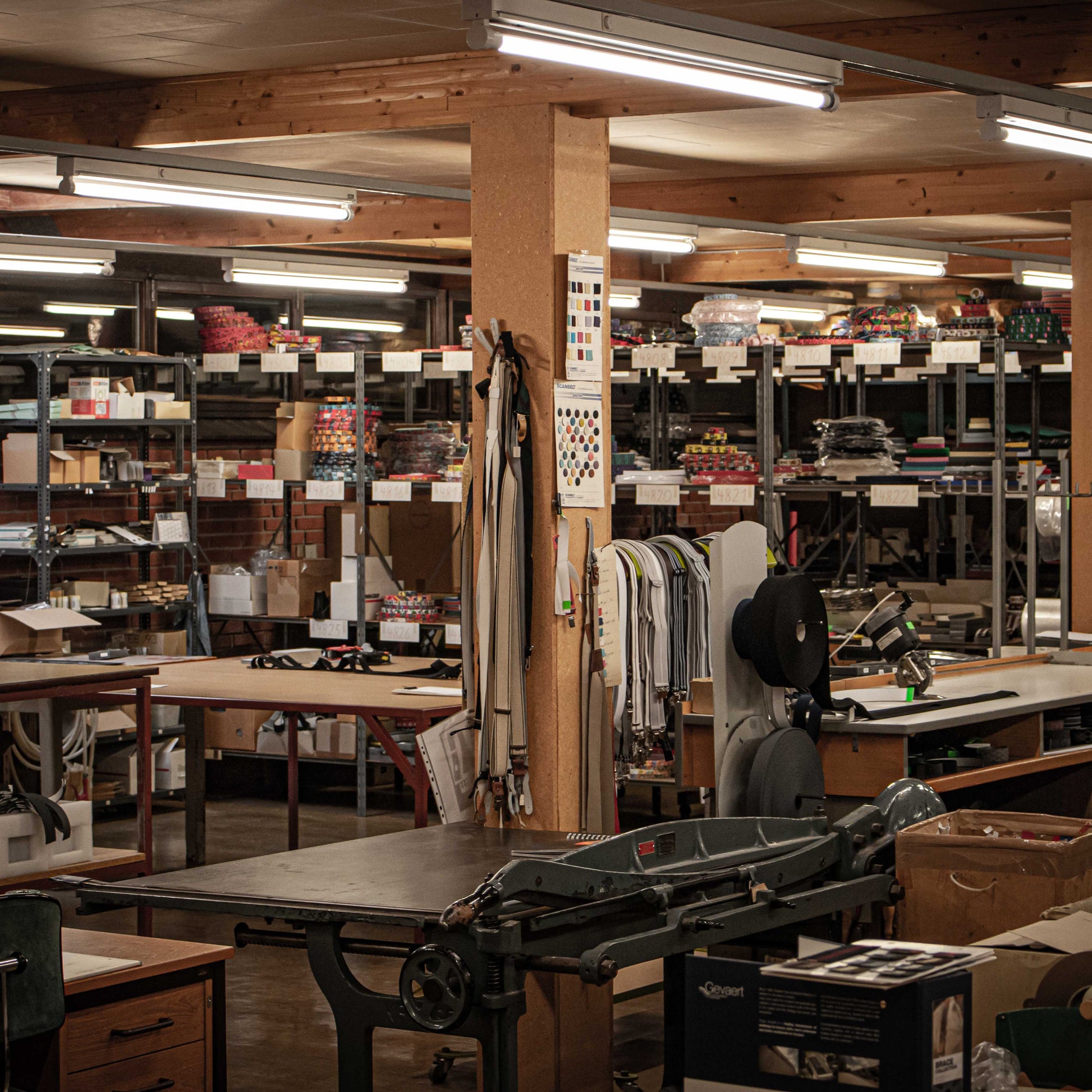 Large leather workshop with various tools and equipment on shelves and tables.