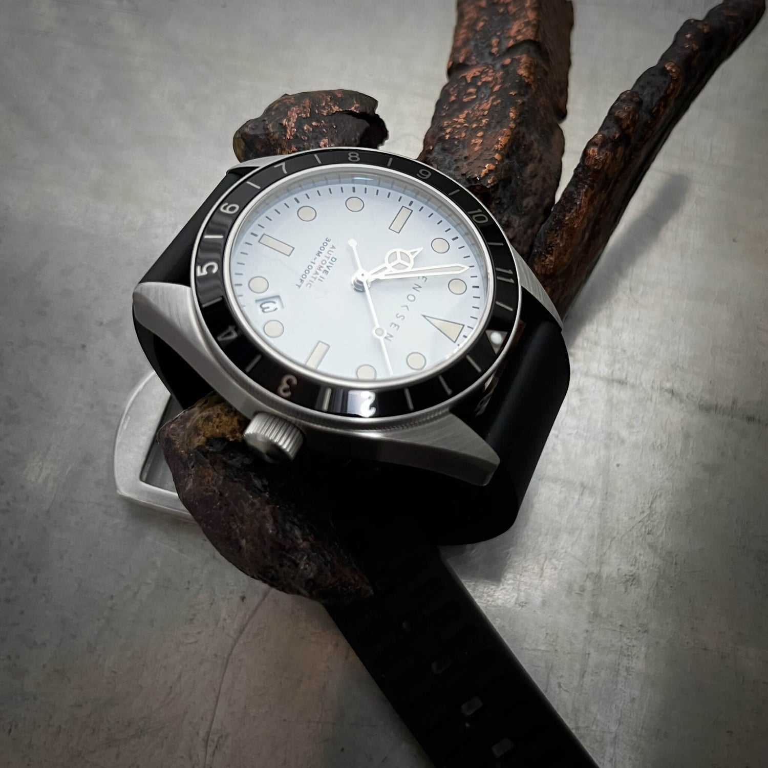 Dive II white dial on black rubber strap, angled view of the Dive II with white dial on black rubber strap, highlighting the domed sapphire crystal and 12-hour bezel.