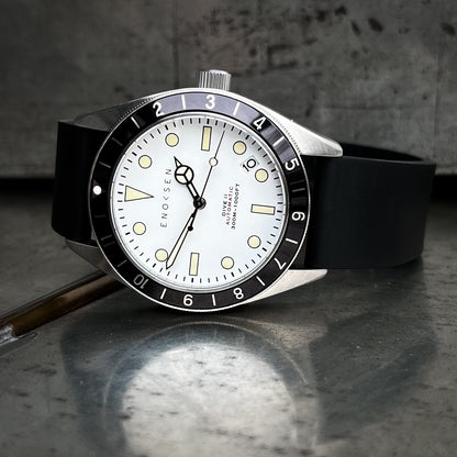 Enoksen Dive II E12/A Skin Diver 39mm with white dial on black rubber strap, front view. View on a metal surface with reflection.