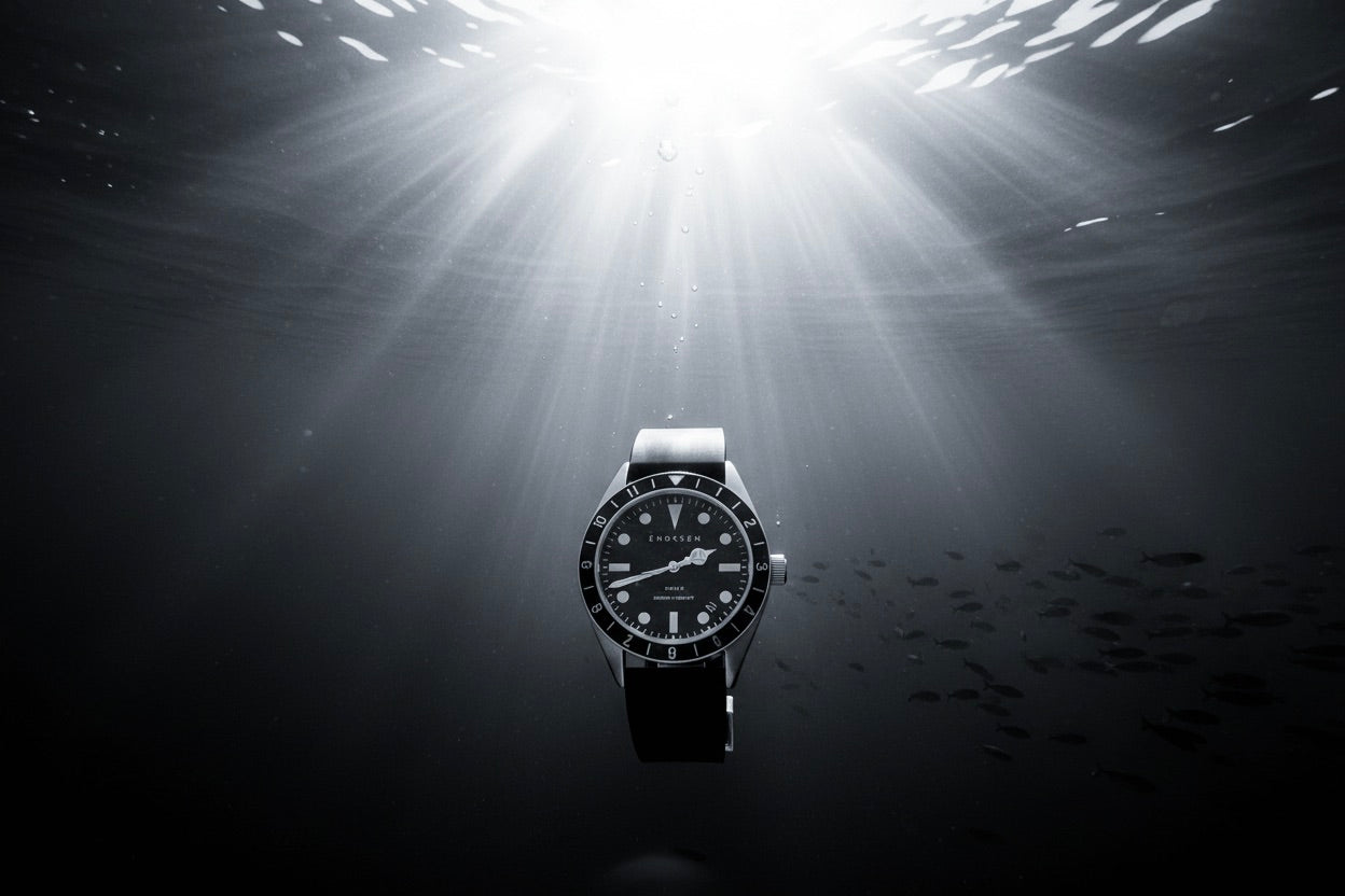 Underwater light beams with the Dive II faintly visible, used as section background for 300m water resistance
