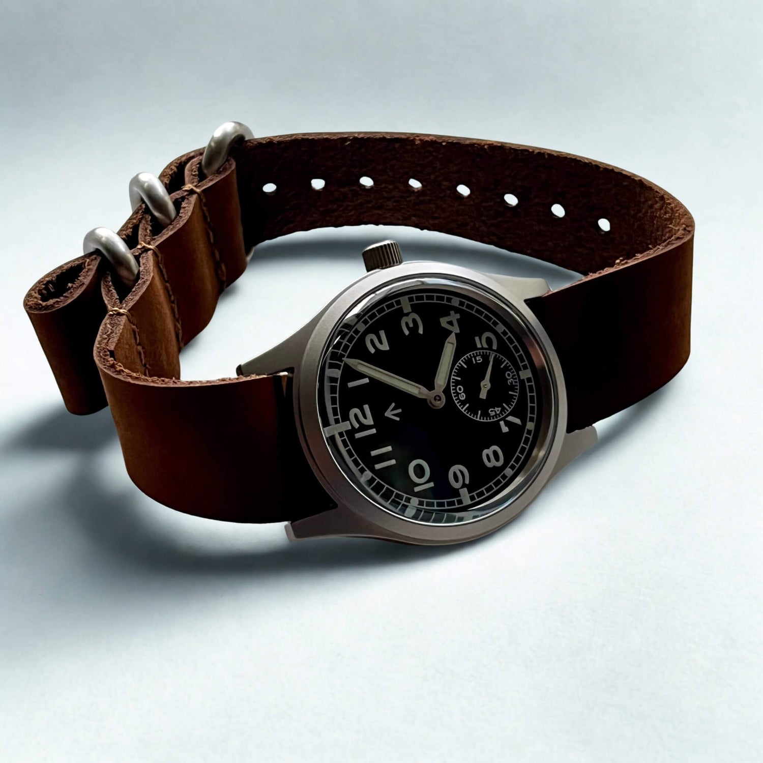 Enoksen Swiss Dirty Dozen watch with soft brown leather strap on a light gray background