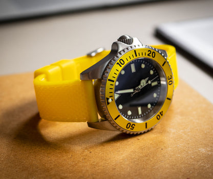 Watch with a yellow strap on a wooden surface