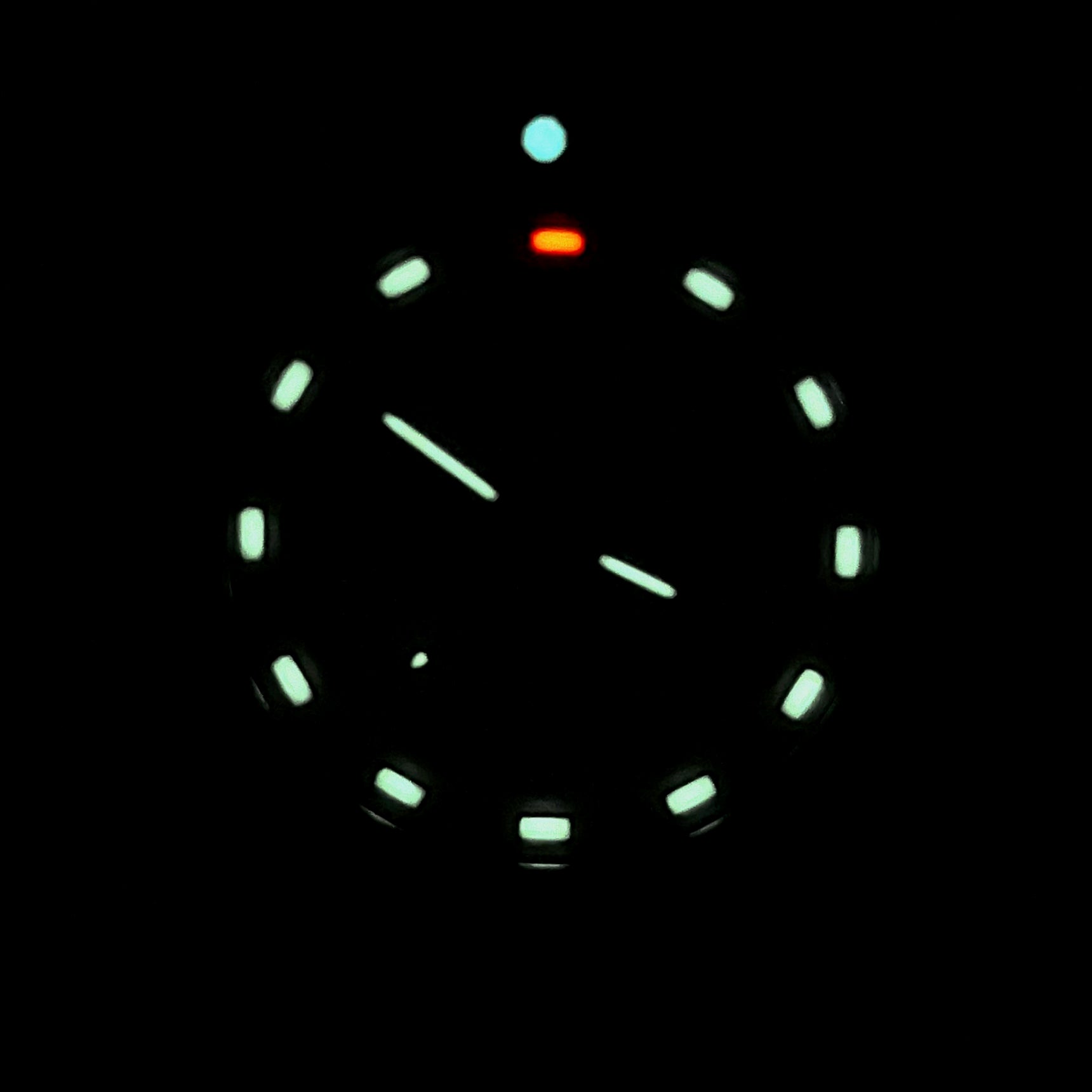Enoksen Tactic E09/BQ Swiss Quartz wristwatch with a sandblasted steel case, white dial with green and orange Tritium luminescent markers, black rotating 12-hour bezel, and khaki military style nylon strap, in complete darkness.