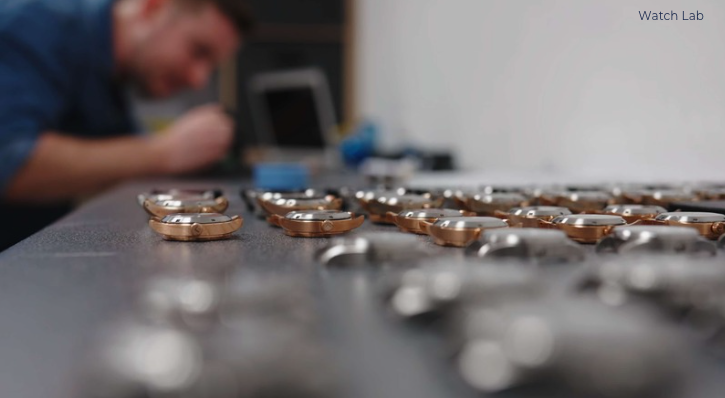 Man assembling and testing watches on workbench at Enoksen Watches.